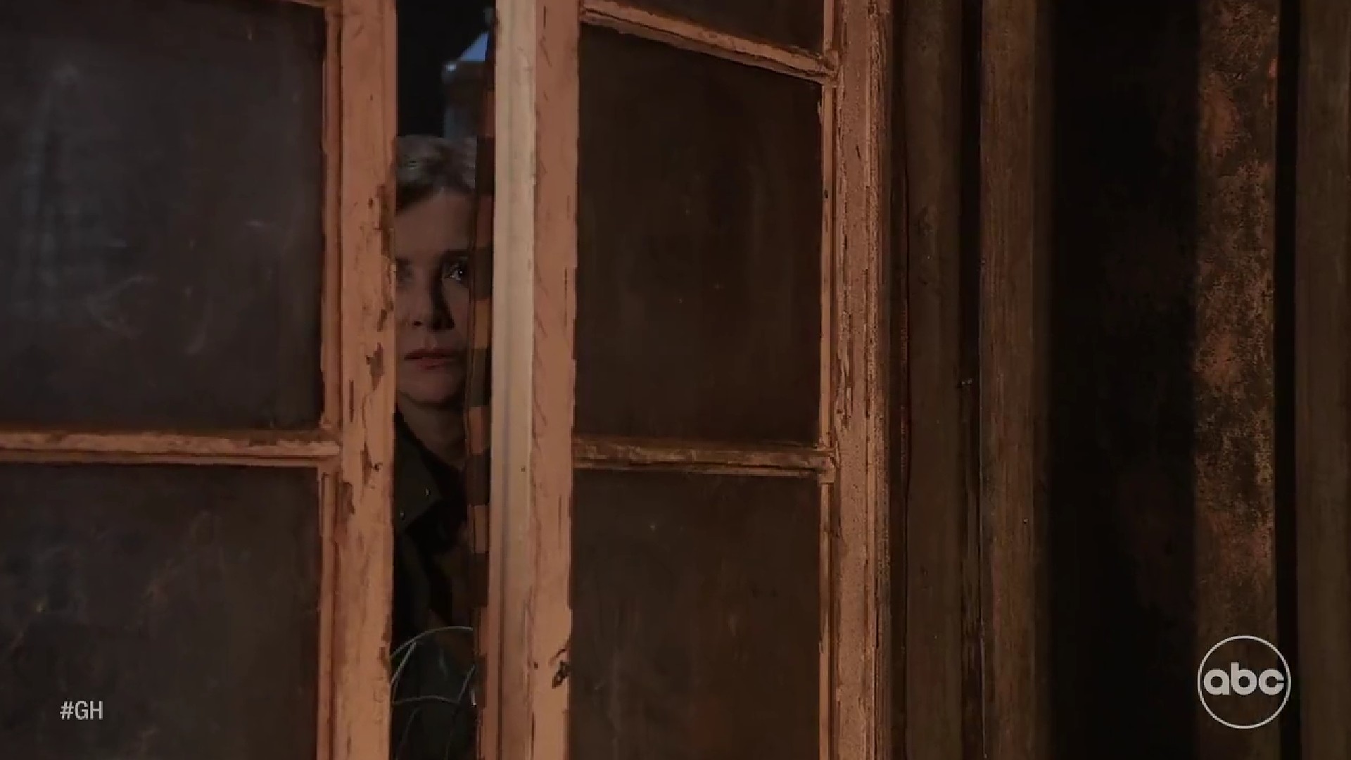 GH/Holly Sutton (Emma Samms) peeks from her hideout